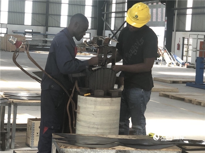 經(jīng)貿(mào)合作區(qū)廠房內(nèi)，當(dāng)?shù)毓と苏诰o張作業(yè)。人民網(wǎng)記者 黃培昭攝