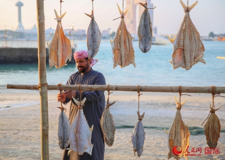  手工藝者展示如何晾曬魚干。人民網(wǎng) 塔里克·易卜拉欣攝