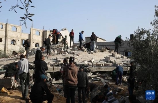  3月3日，在加沙地帶南部城市拉法，人們查看被以軍空襲破壞的建筑。新華社發(fā)（哈立德·奧馬爾攝）