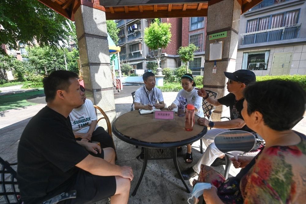 △2023年7月21日，在位于浙江杭州臨安區(qū)錦南街道水岸陽光小區(qū)的陽光議事廳，街道干部在聽取居民們反映的問題及意見。