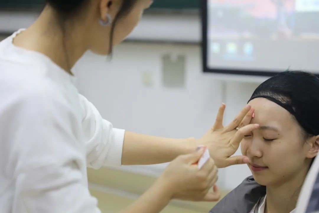 課堂上，一名學(xué)生在體驗(yàn)上戲妝。學(xué)校供圖