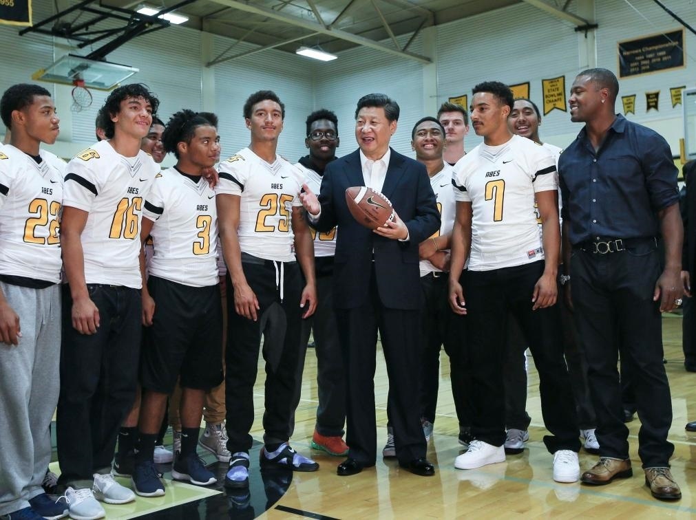 2015年9月23日，國家主席習(xí)近平參觀美國塔科馬市林肯中學(xué)。這是習(xí)近平在學(xué)校體育館，同上橄欖球訓(xùn)練課的學(xué)生們親切交談。新華社記者 蘭紅光 攝