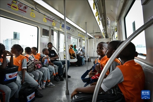2月28日，在尼日利亞拉各斯，一所小學的學生們體驗乘坐輕軌藍線列車。新華社記者 韓旭 攝