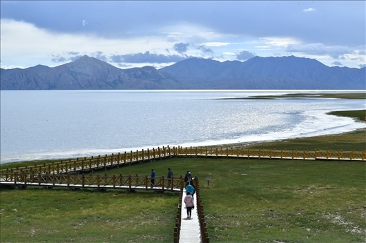 △ 游客行走在青?，敹嗫h冬格措納湖畔的木棧道上。