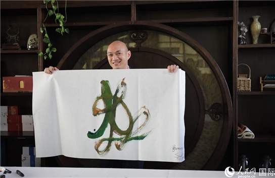 老撾駐華大使館三秘明君參加《五百筆·瀾湄合作》集體藝術創(chuàng)作。人民網(wǎng)王婧攝。