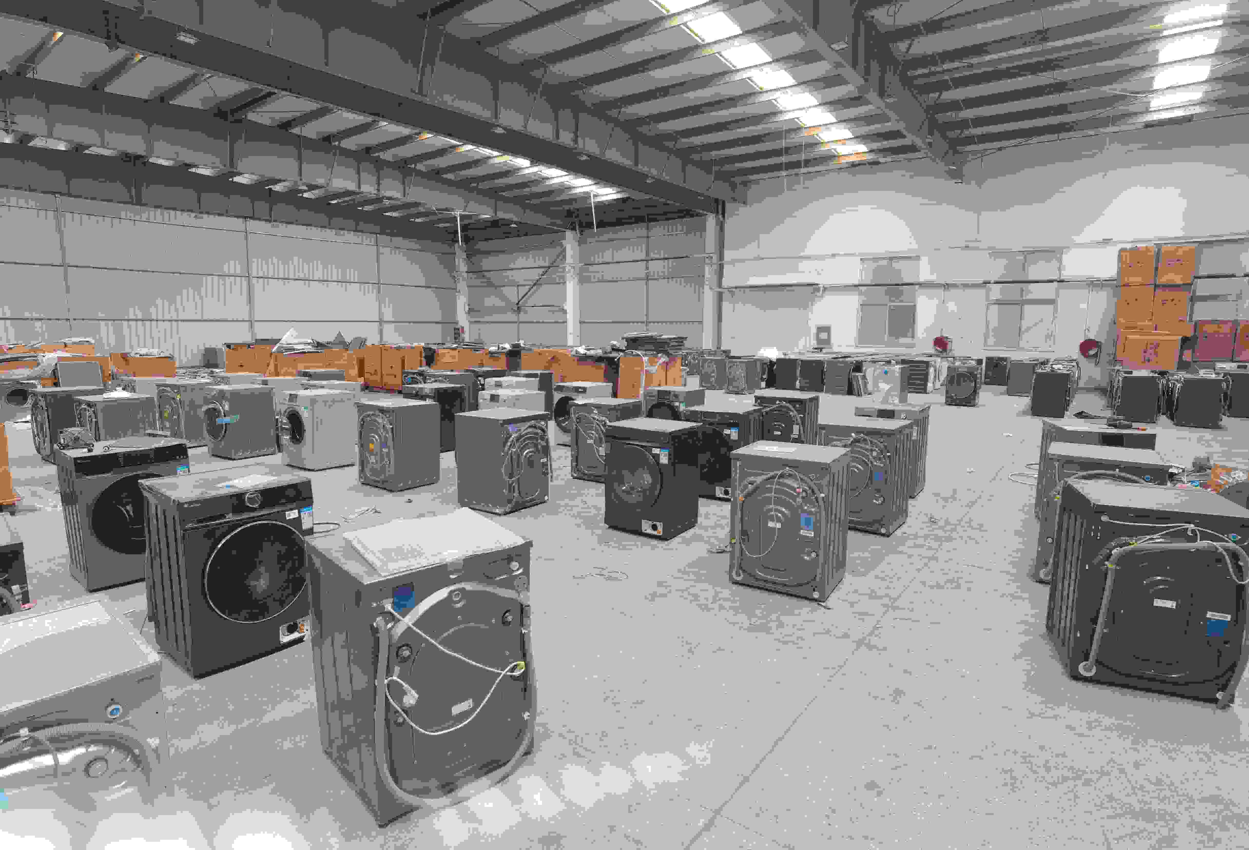 專(zhuān)案組民警查扣涉案場(chǎng)所及假冒知名品牌洗衣機(jī)。巨野警方供圖