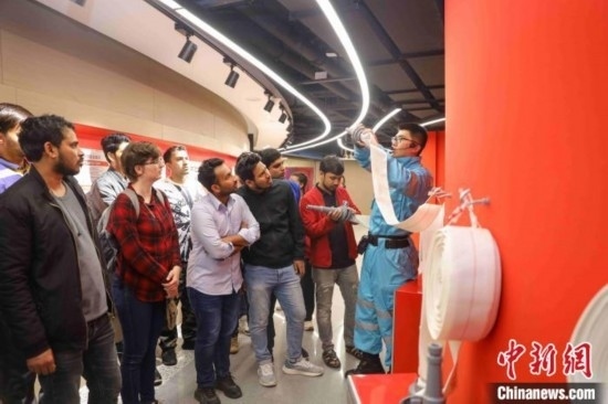 5月9日，工作人員指導(dǎo)留學(xué)生正確使用消防水帶。張鷹 攝