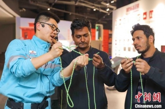 5月9日，工作人員指導(dǎo)留學(xué)生學(xué)習(xí)打繩結(jié)。張鷹 攝