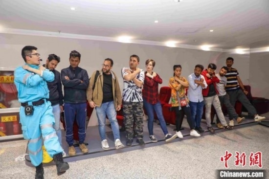 5月9日，工作人員指導(dǎo)留學(xué)生練習(xí)逃生技巧。張鷹 攝