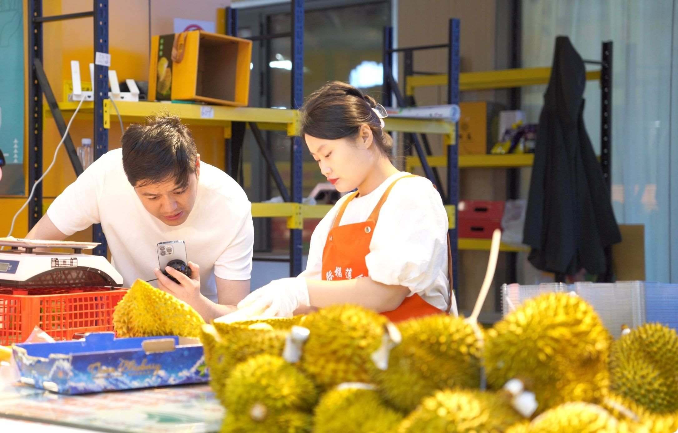 榴蓮商家正在通過(guò)手機(jī)直播銷(xiāo)售榴蓮。人民網(wǎng)記者申佳平 攝