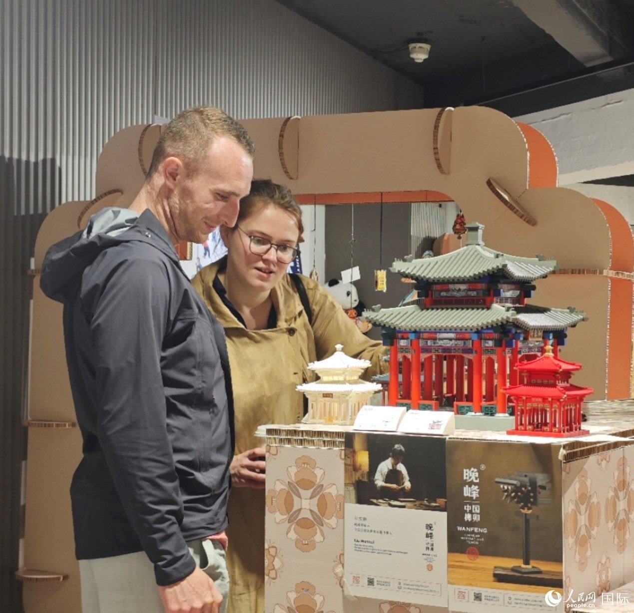 英國觀眾在欣賞中國傳統(tǒng)榫卯結構建筑模型。邢雪攝