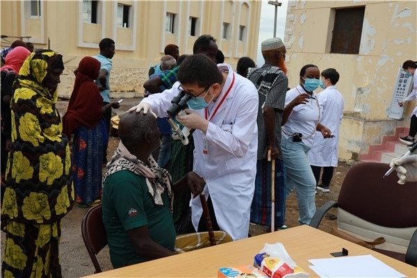 在義診現(xiàn)場，中國醫(yī)生與當(dāng)?shù)鼐用窈嫌傲裟?，吉布提鹽業(yè)投資公司供圖
