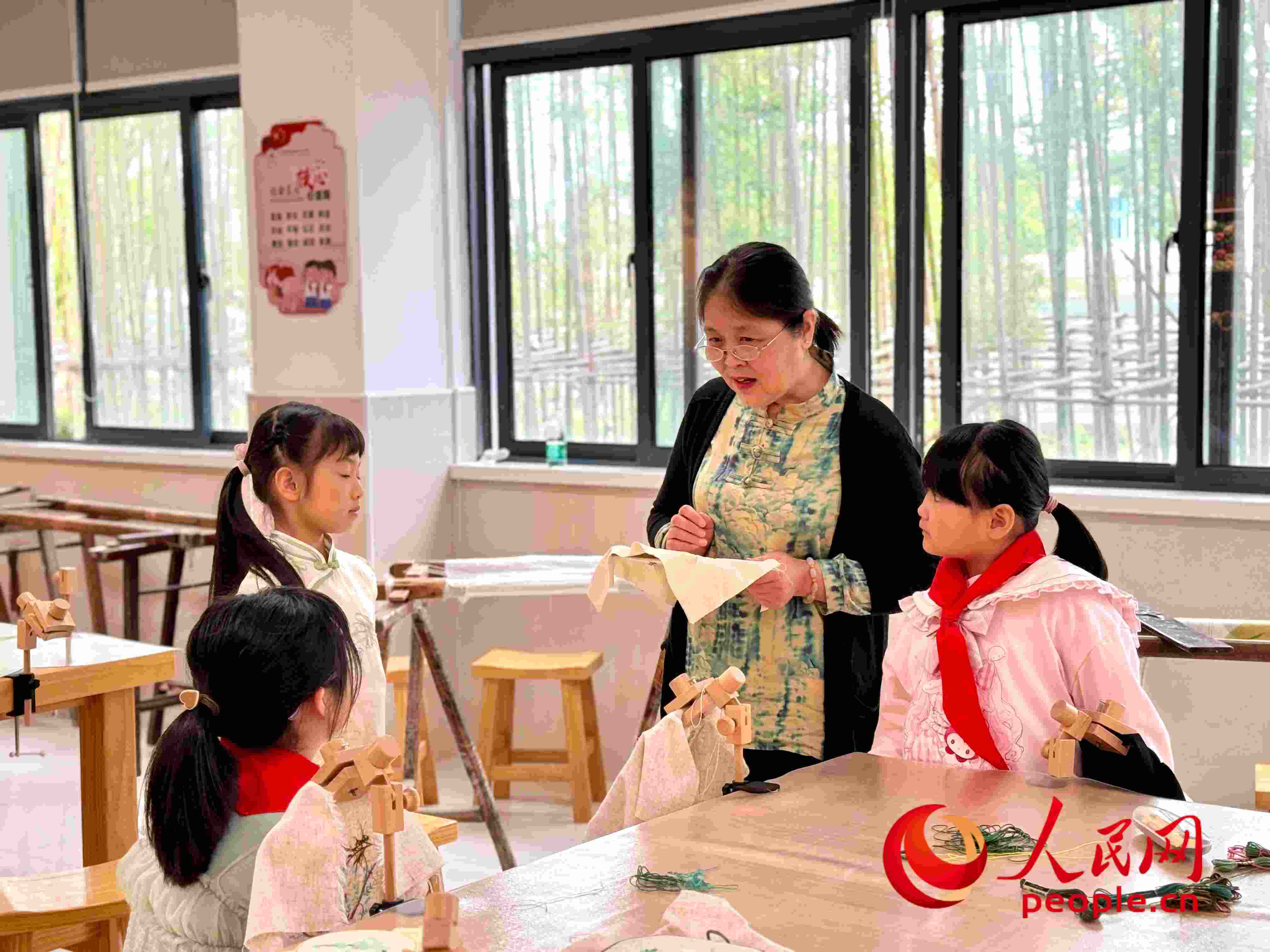 顧建珍（左三）在教孩子們刺繡知識(shí)。人民網(wǎng) 周靜圓攝