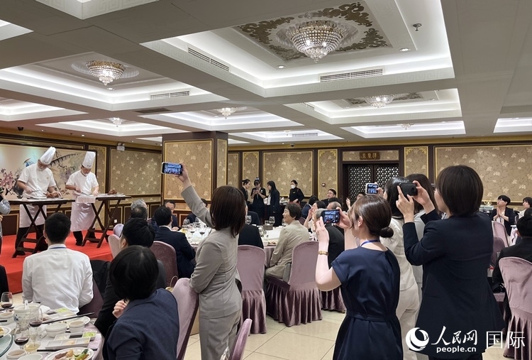 國家級非物質(zhì)文化遺產(chǎn)、全聚德片鴨工藝吸引代表團(tuán)成員拍照留念。