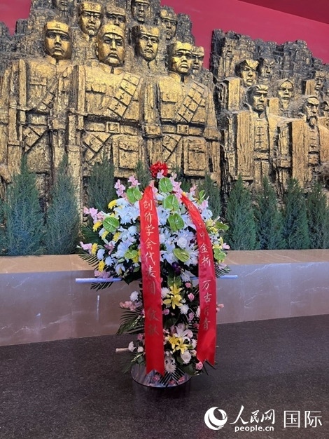 創(chuàng)價學(xué)會青年代表團(tuán)敬獻(xiàn)的花籃上，寫有“愿日中金橋萬古長青”。人民網(wǎng)記者 陳思攝