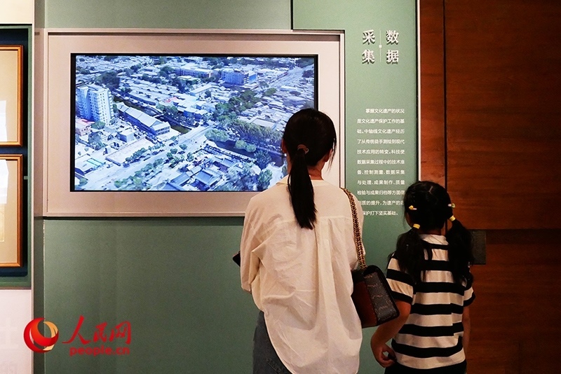 家長正在帶孩子參觀“輝煌中軸”專題展。人民網(wǎng)記者 韋衍行攝