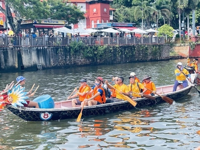 多元種族共同奮輯前進(jìn)，體驗(yàn)在馬六甲河劃龍舟，引來(lái)大批游客駐足圍觀。組委會(huì)供圖