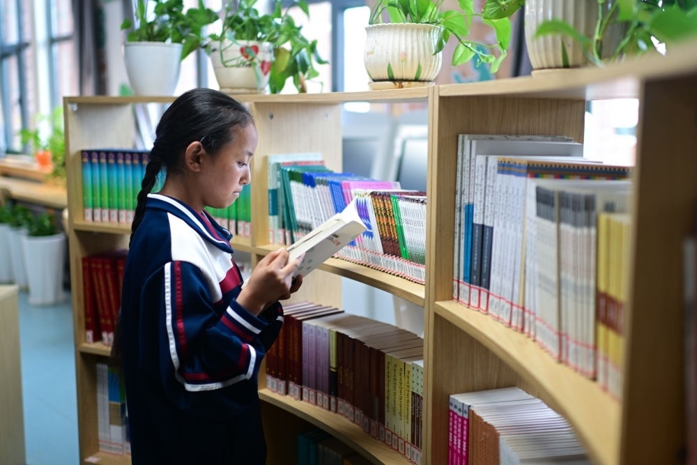 6月18日，果洛西寧民族中學(xué)學(xué)生尼東拉毛在圖書室看書。