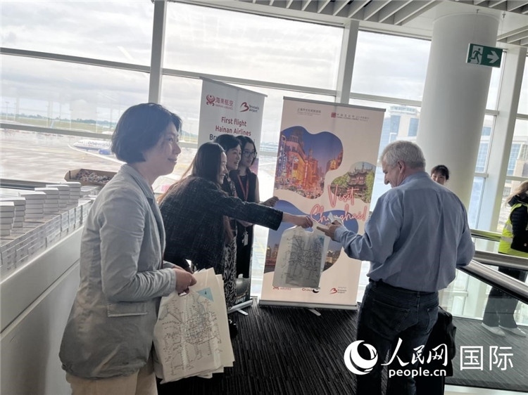 圖為工作人員向乘客發(fā)放復(fù)航首班禮物。 牛瑞飛攝