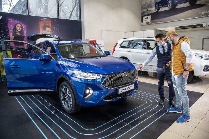 2021年4月1日，銷售人員在哈薩克斯坦阿拉木圖市經(jīng)銷商店向消費(fèi)者介紹哈弗汽車。新華社發(fā)（阿斯塔納汽車公司供圖）