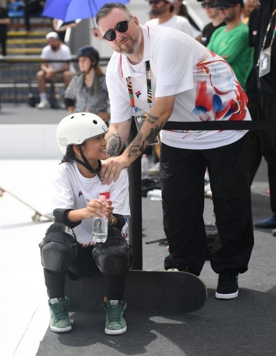 6月20日，鄭好好（左）在比賽間隙與教練互動，她在預賽中最佳成績?yōu)?2.60分。當日，巴黎奧運會資格系列賽布達佩斯站滑板女子碗池預賽在布達佩斯舉行。新華社記者 賀燦鈴 攝