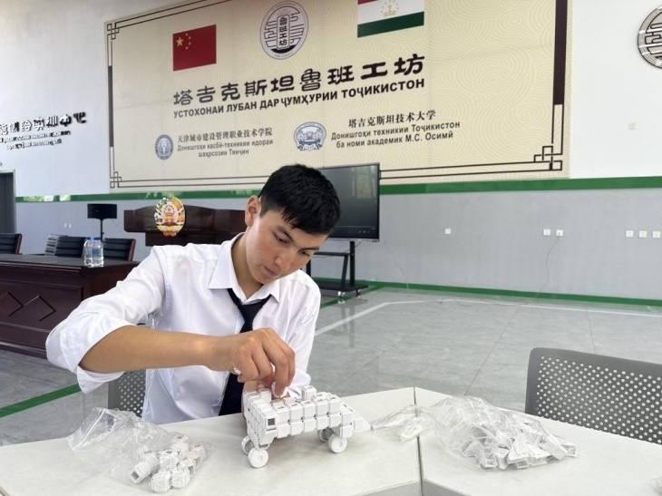 在塔吉克斯坦魯班工坊內(nèi)，學員正在操作能力源創(chuàng)新套件。本報記者 屈佩 攝