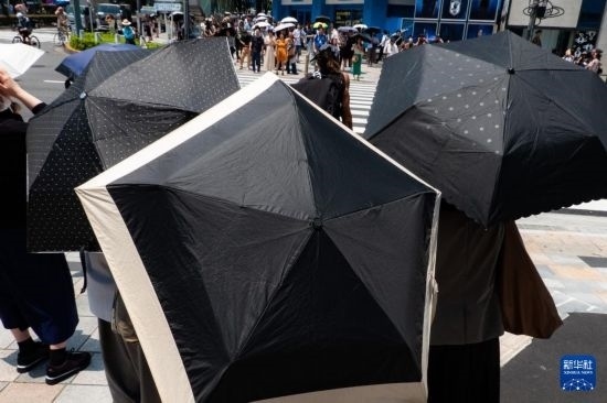 7月4日，人們在日本東京原宿的街道上等待紅綠燈。新華社記者 張笑宇 攝