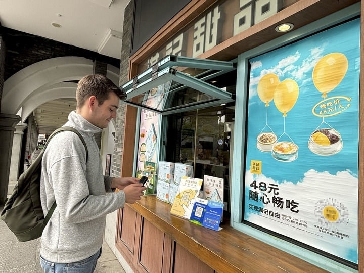 來(lái)自德國(guó)的留學(xué)生理查德在杭州西湖邊一家商鋪使用支付寶掃碼支付（2024年4月11日攝）。新華社發(fā)