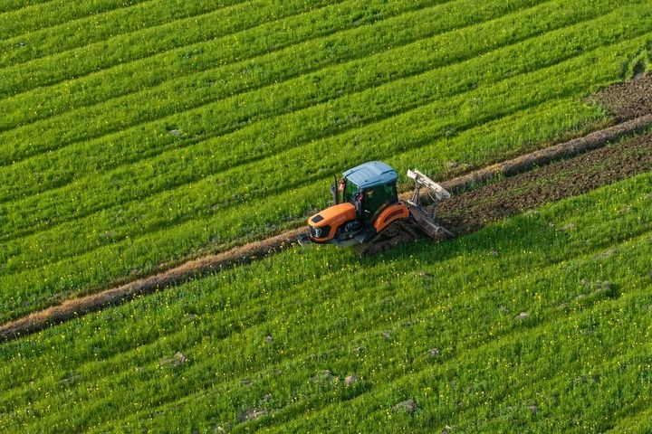 2024年3月19日，在湖南省常德市鼎城區(qū)謝家鋪鎮(zhèn)港中坪村，村民駕駛農(nóng)機(jī)翻耕田地（無人機(jī)照片）。新華社記者 陳思汗 攝