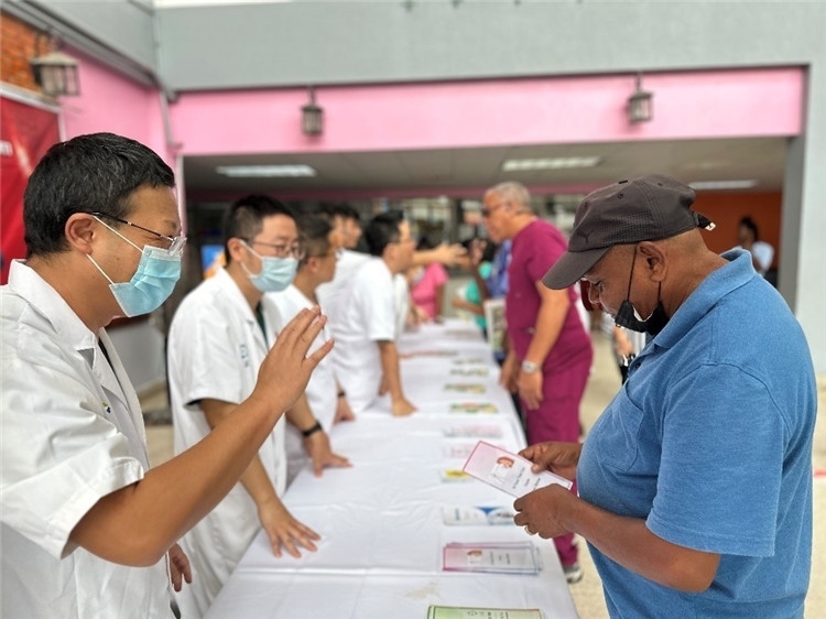 援圭醫(yī)療隊隊員們在啟動儀式上為當?shù)孛癖姺职l(fā)宣傳手冊。中國援助圭亞那醫(yī)療隊供圖