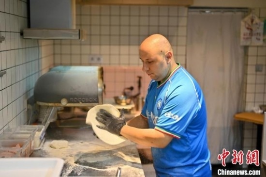 近日，韋榮耀在自家披薩小店內(nèi)忙活。俞靖 攝