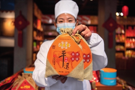 在位于山西省晉中市平遙縣的平遙古城南大街的一家平遙牛肉店內(nèi)，工作人員展示一款牛肉產(chǎn)品（資料照片）楊晨光攝 / 本刊