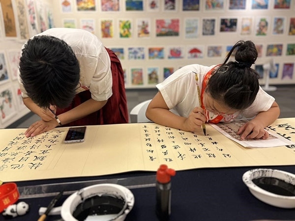 參加本次展覽的青少年在現(xiàn)場進行書法創(chuàng)作。主辦方供圖