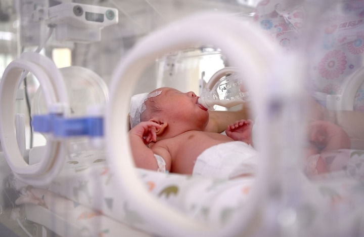 2024年6月1日，在西安國(guó)際醫(yī)學(xué)中心醫(yī)院新生兒科病房，護(hù)士為新生兒喂奶。 新華社記者 劉瀟 攝