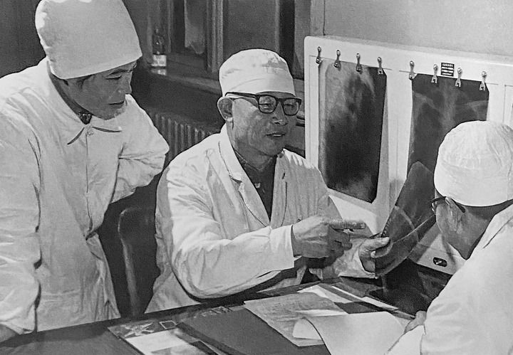 1980年1月16日，中日友好醫(yī)院首任院長(zhǎng)辛育齡（中）在內(nèi)蒙古結(jié)核病院與胸外科醫(yī)師討論病例（翻拍照片）。 新華社發(fā)