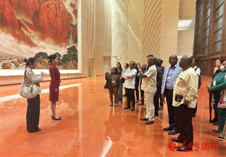 代表團(tuán)在入口處聽取講解。人民網(wǎng) 曹欣悅攝