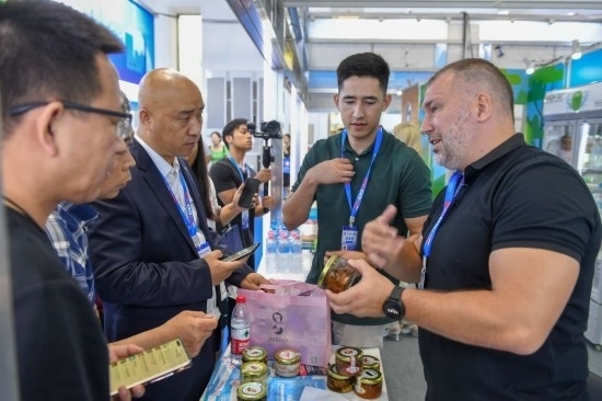 2023年8月23日，在第十四屆中國(guó)—東北亞博覽會(huì)東北亞商品館，俄羅斯參展商向參觀者介紹商品。