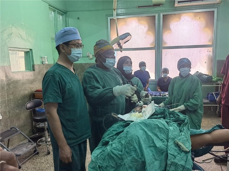 隊長蔣國慶（左一）關(guān)注當?shù)蒯t(yī)生手術(shù)情況。中國援桑醫(yī)療隊供圖