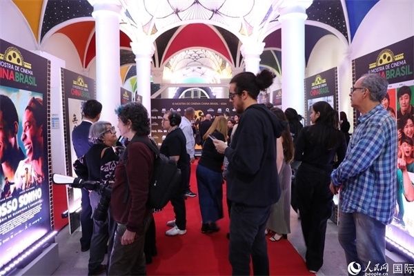 為期4天的第三屆中國(guó)－巴西電影展期間，來(lái)自中巴兩國(guó)的14部參展影片受到巴西電影愛(ài)好者和社會(huì)各界人士好評(píng)，圖為當(dāng)?shù)赜^眾在影展舉辦地巴西里約熱內(nèi)盧勞拉—阿爾維姆文化之家的迎賓廳欣賞參展電影海報(bào)。 人民網(wǎng)記者 陳一鳴攝