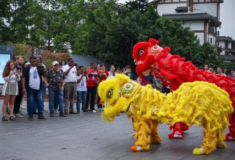 2024“一帶一路”媒體合作論壇聯(lián)合采訪調(diào)研行成員在樂山蘇稽古鎮(zhèn)觀看非遺舞獅表演。本報記者 伊霄攝