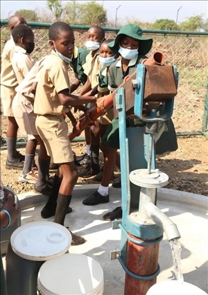 △2021年11月，在津巴布韋南馬塔貝萊蘭省省會關(guān)達的塞農(nóng)多小學(xué)，學(xué)生從中國援建水井里打水。