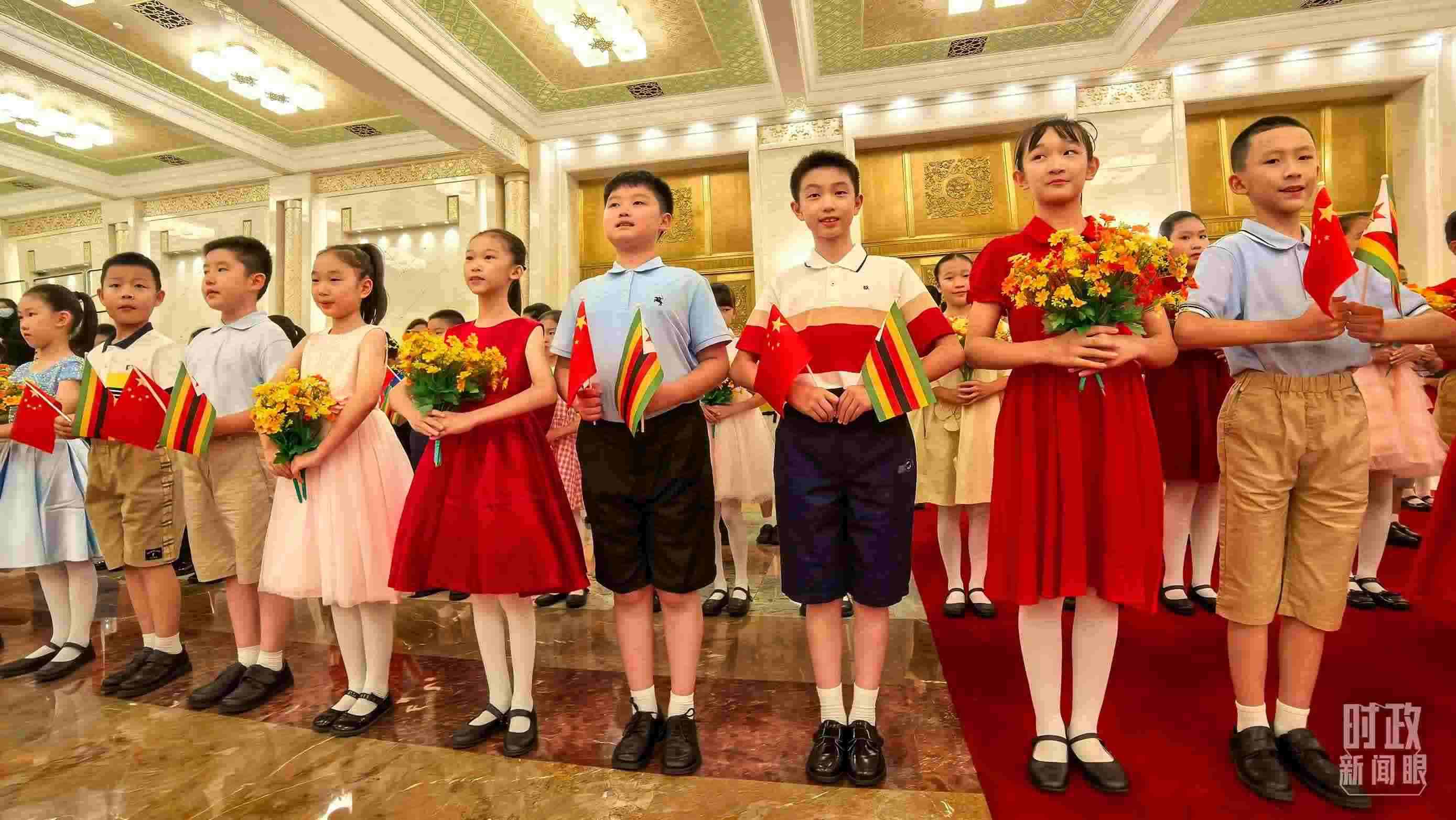 △現(xiàn)場歡迎津巴布韋總統(tǒng)訪華的青少年。（總臺央視記者鐘銳拍攝）