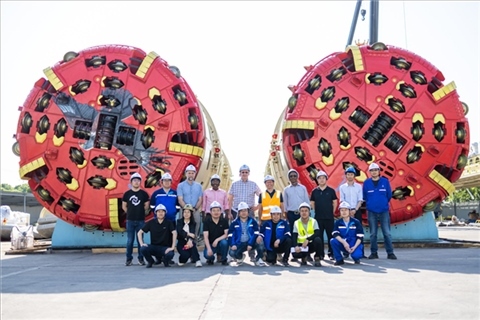 中外員工在盾構(gòu)機(jī)前合影。中國(guó)電建供圖