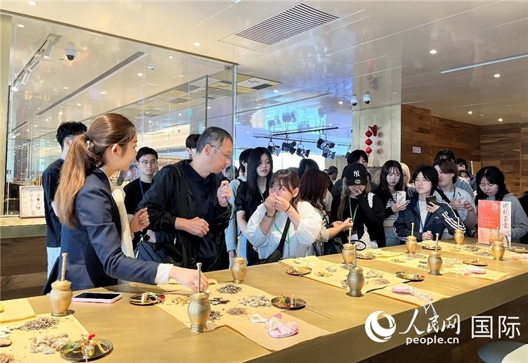 1. 日中友好協(xié)會青年代表團(tuán)一行學(xué)習(xí)中醫(yī)香囊制作工序。（人民網(wǎng)記者陳思 攝）