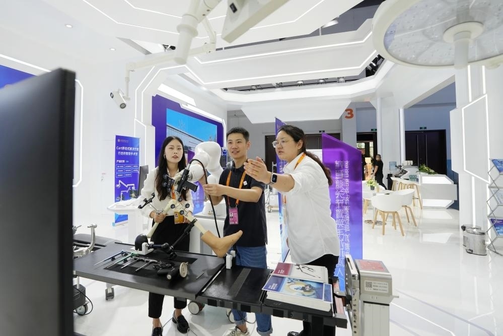 9月11日，一位媒體記者（中）在2024年服貿(mào)會(huì)國(guó)家會(huì)議中心會(huì)場(chǎng)體驗(yàn)北京納通科技集團(tuán)有限公司的膝關(guān)節(jié)置換手術(shù)機(jī)器人。新華社記者鞠煥宗 攝