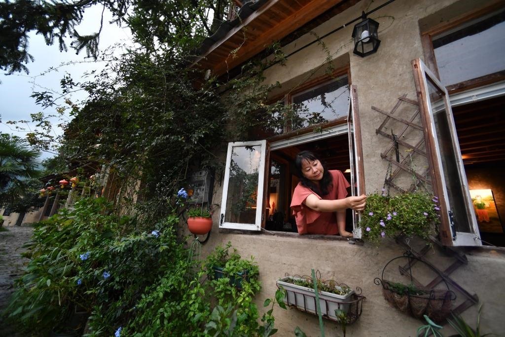 8月29日，在福建省屏南縣熙嶺鄉(xiāng)，龍?zhí)洞濉靶麓迕瘛泵泛暝诖蚶碜约航?jīng)營(yíng)的民宿外墻裝飾花盆。新華社記者姜克紅 攝