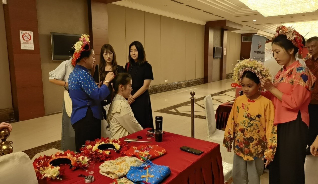 阿拉扎大學(xué)孔子學(xué)院志愿者老師向傳承人學(xué)習(xí)簪花圍。阿拉扎大學(xué)孔子學(xué)院供圖