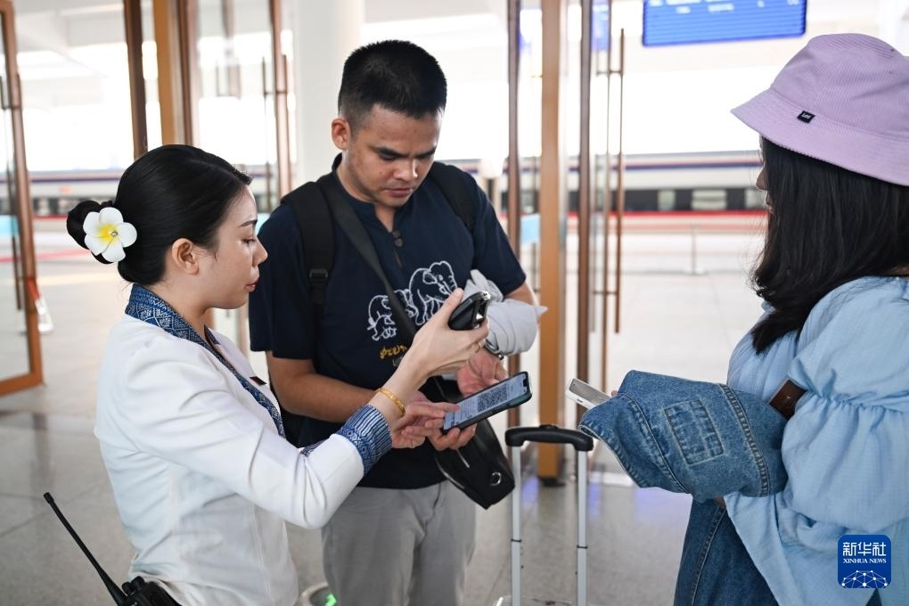 10月12日，在老撾萬象中老鐵路萬象站，工作人員檢驗乘客車票。新華社記者 程一恒 攝