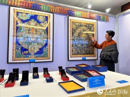 熱貢藝術(shù)國(guó)家級(jí)代表性傳承人夏吾角向嘉賓介紹作品。人民網(wǎng)記者 簡(jiǎn)承淵攝