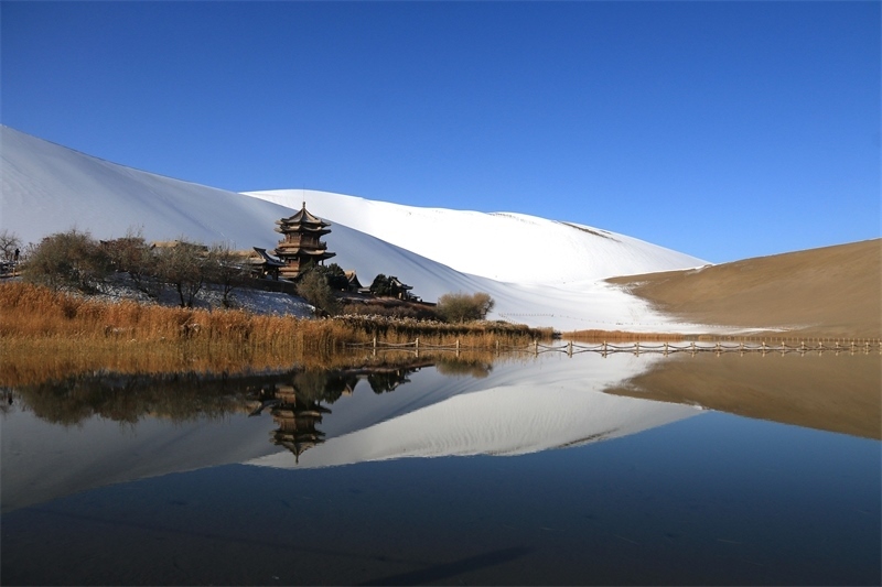 鳴沙山月牙泉景區(qū)雪景。敦煌市委宣傳部供圖，張曉亮攝